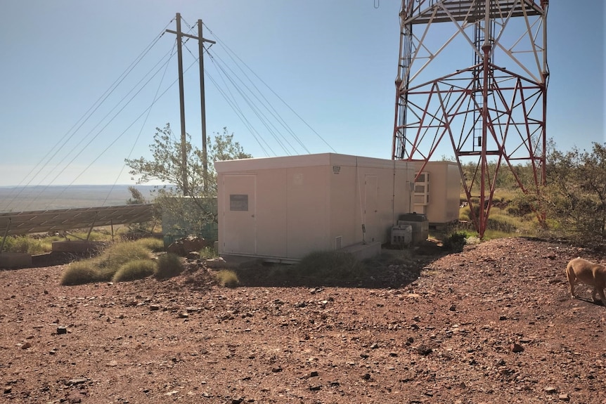 Un edificio y una ciudad de metal en un paisaje de tierra roja.