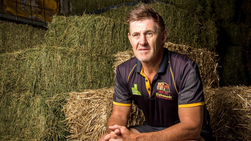 Craig Kirkwood sits on hay bales.