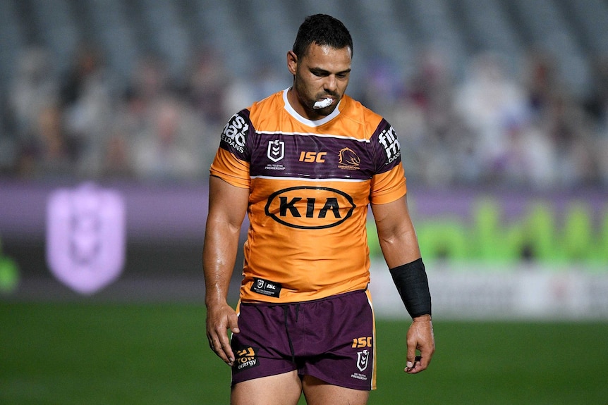 A dejected Broncos player walks off with his mouthguard out.