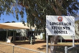 The Longreach Students Hostel sign in front of a collection of buildings.