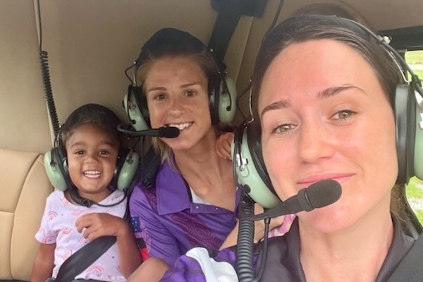 Two women a child in a helicopter.