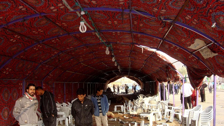 Residents inspect the site of the attack inside a funeral tent.