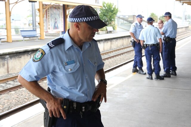 A Newcastle officer with the NSW Police Transport Command speaks with a commuter, generic