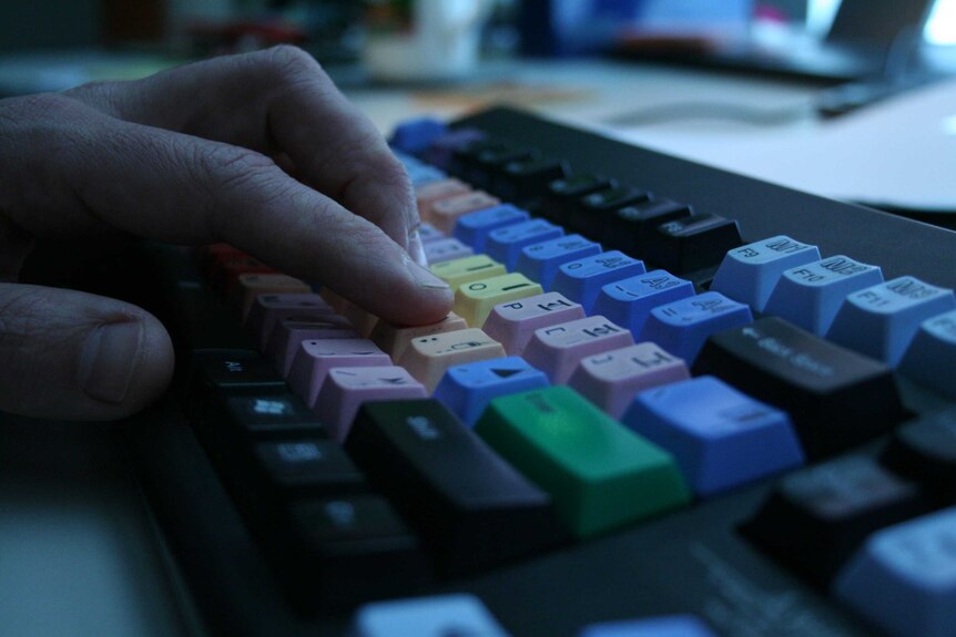 Close up editor Guy Bowden's fingers on keyboard.