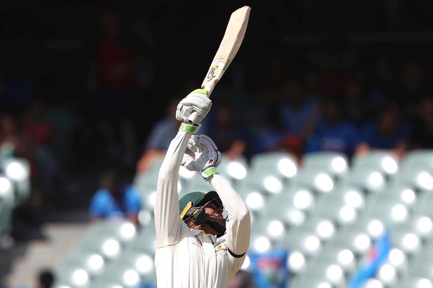 Australian batsman Usman Khawaja points his bat skyward.