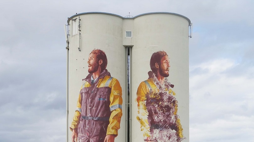 Silo in Norway painted with two workers on it