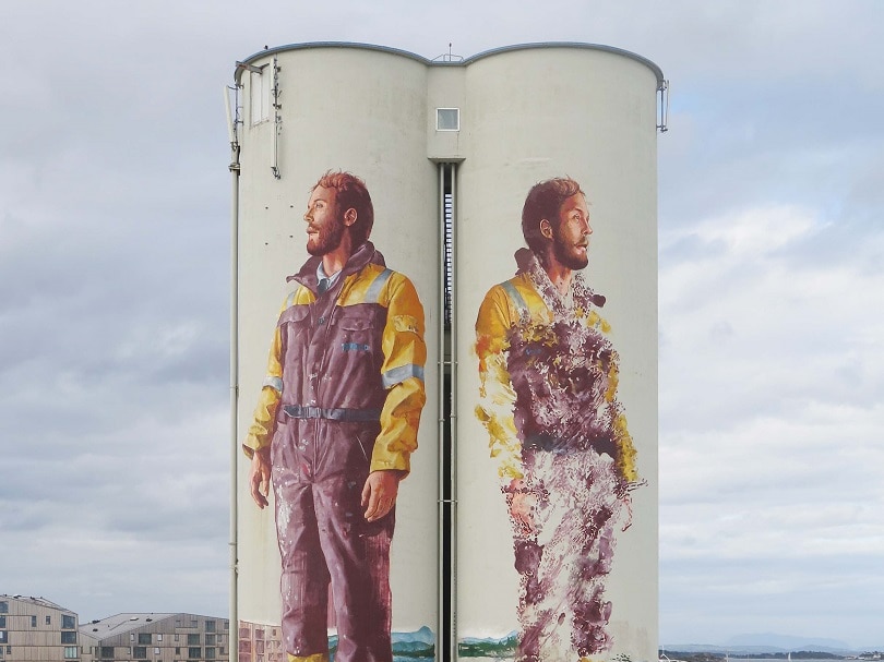 Silo in Norway painted with two workers on it