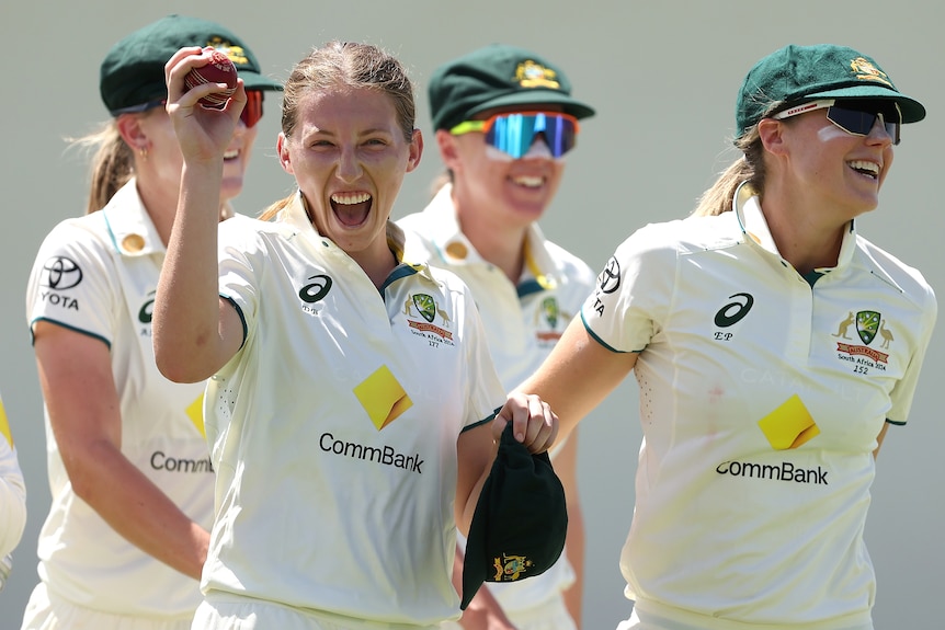 Darcie Brown smiles and holds a cricket ball