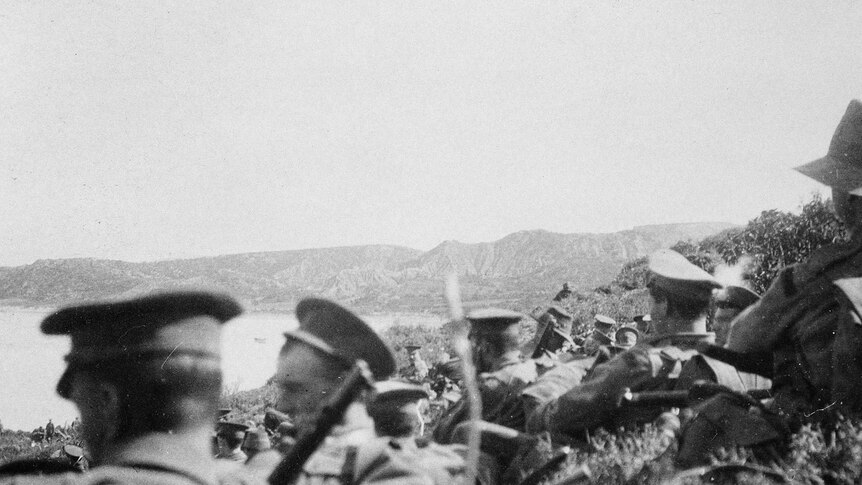 Soldiers of the 1st Battalion, Australian Imperial Force, await orders from the southern edge below Plugges Plateau. Colonel Dobbin is in the centre mid-ground, to the left of the branch.