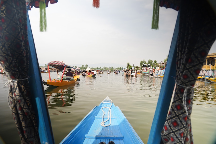 A boat looks out over a river, surrounded by other boats.