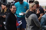 Tom Hiddleston and Chris Hemsworth smile at onlookers on filem set in Brisbane's CBD.