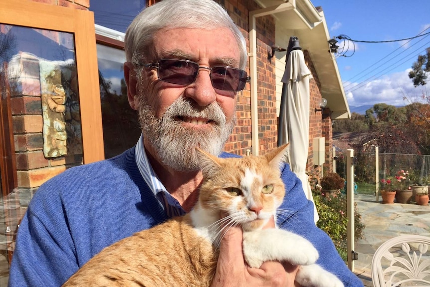 John Hargreaves holds his ginger cat.
