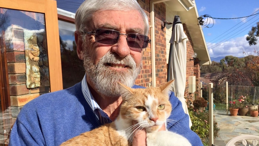 John Hargreaves holds his ginger cat.