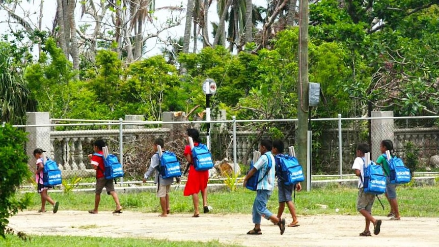 Kids wearing backpacks walking to school