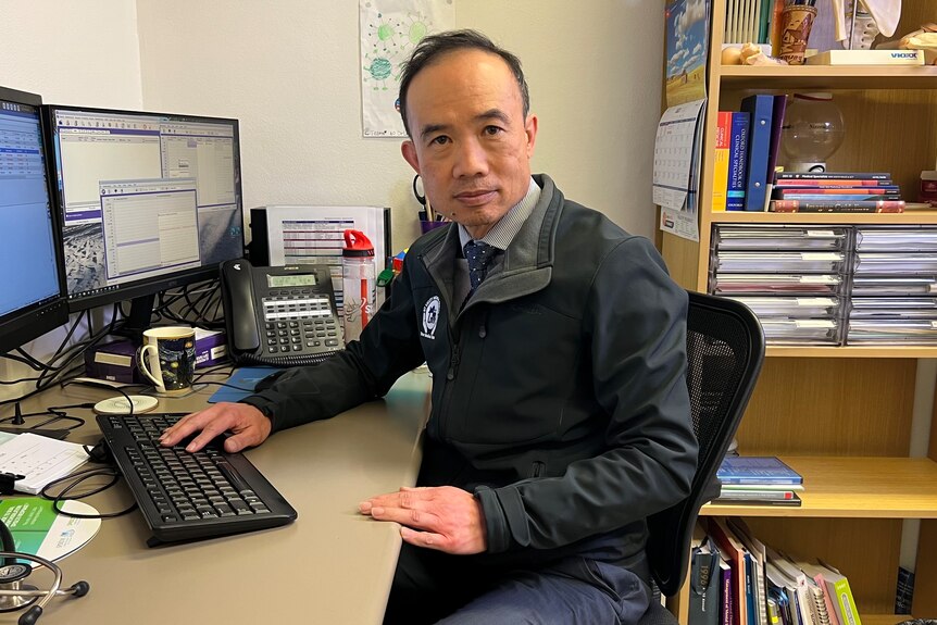 Dr Kean-seng Lim sitting at a desk in his office