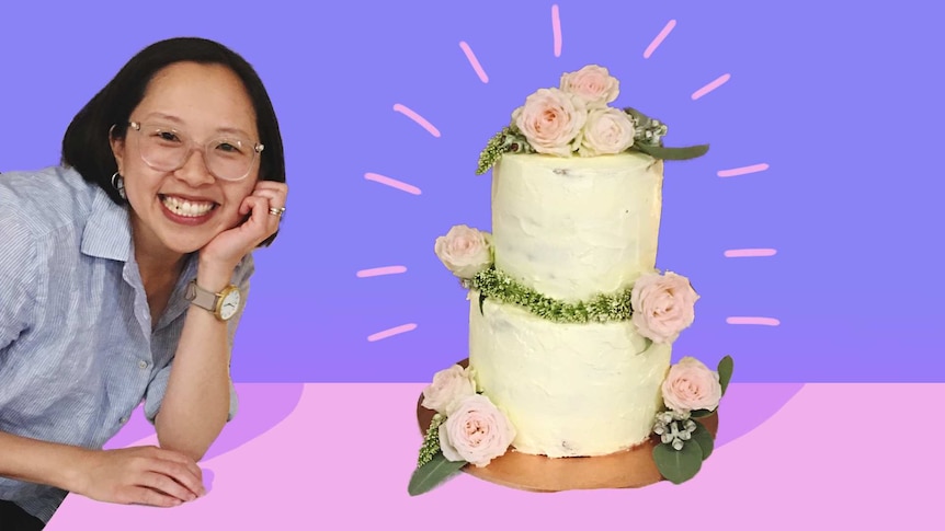 A woman poses with a wedding cake she made at home, a gift for her brother, in a story about baking wedding cakes at home.