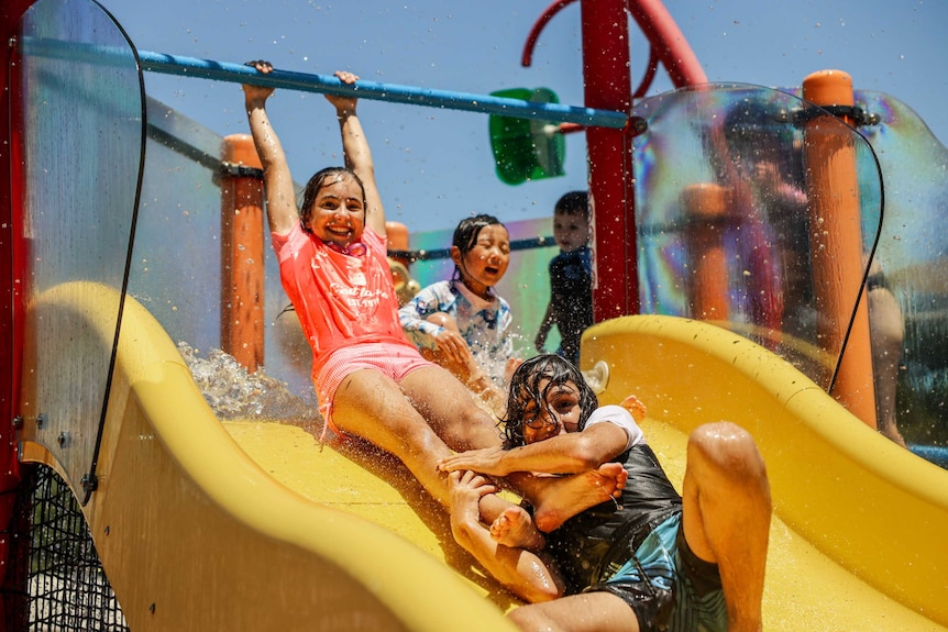 Kids play on a water slide
