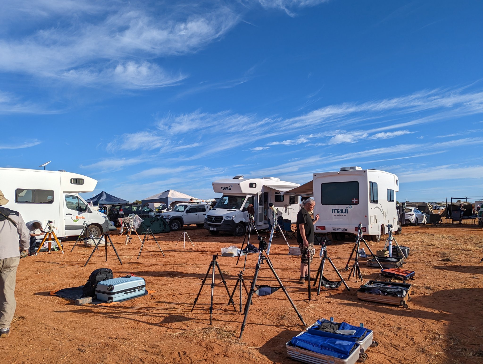 Telescopes, cameras and tripods set up in the middle of a campsite.
