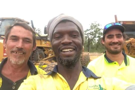 three men in hi-vis construction gear on site