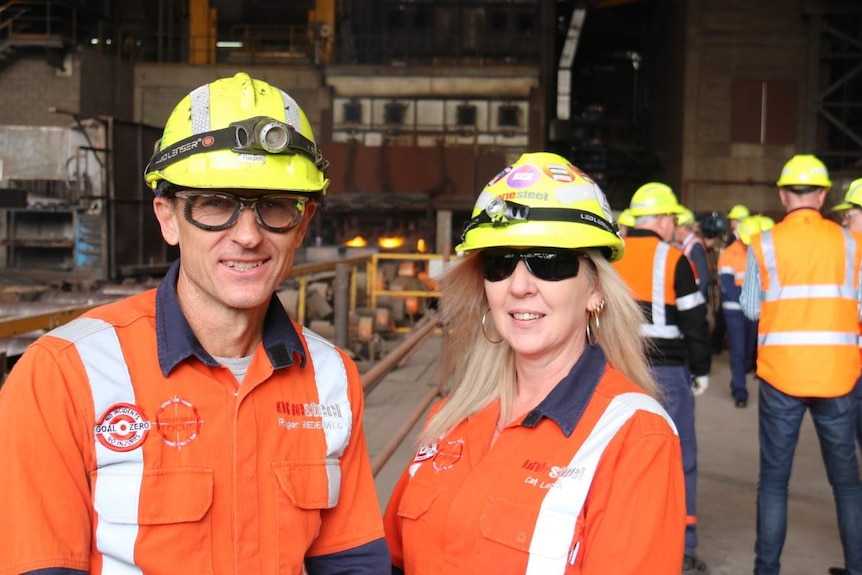 Two workers in hard hats and glasses at the steelworks.