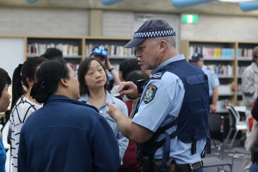 A police officer speaking to members of the Vietnamese community