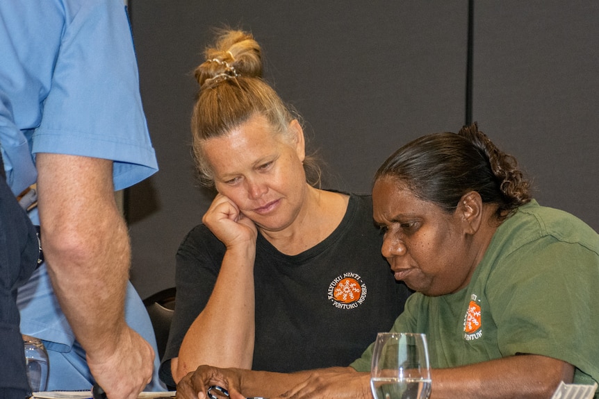 A Martu woman using a map and compass