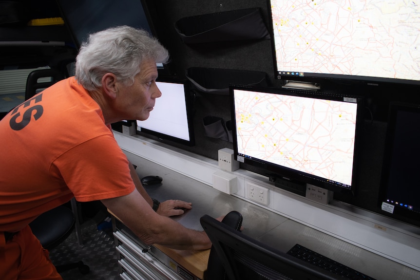 Man in SES uniform looks at communications screen