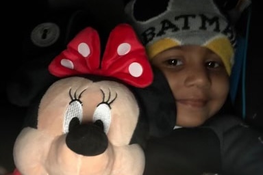 Hetvi wears a batman beanie on her head, while holding a large plush Minnie Mouse toy.