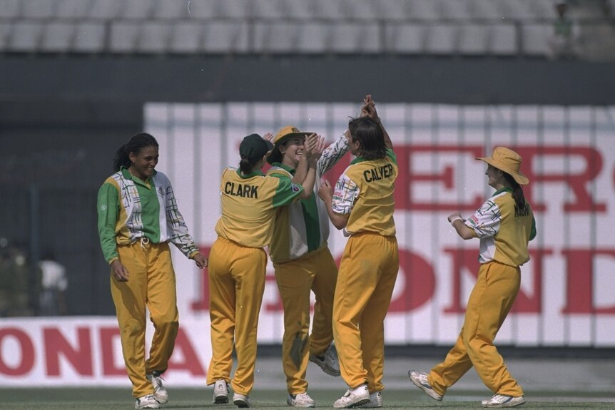 Australia women celebrate a wicket as they run towards each other to hi-5