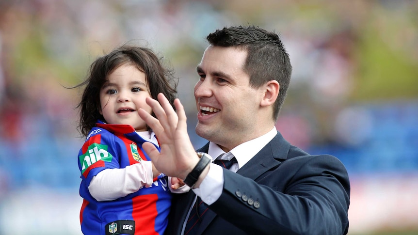 Former Newcastle Knights player James McManus with his daughter Evelyn at Hunter Stadium in Newcastle.