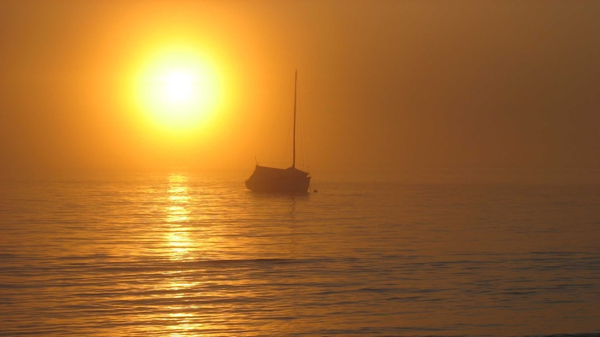 Sunset over a bay in Tasmania, boat on water. Generic suitable for climate change.