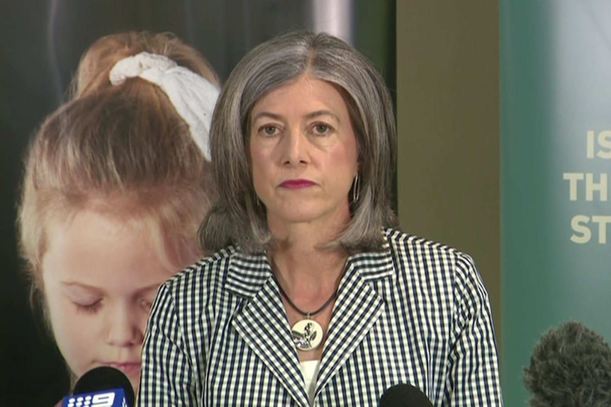 A woman with grey hair wearing a checked jacket