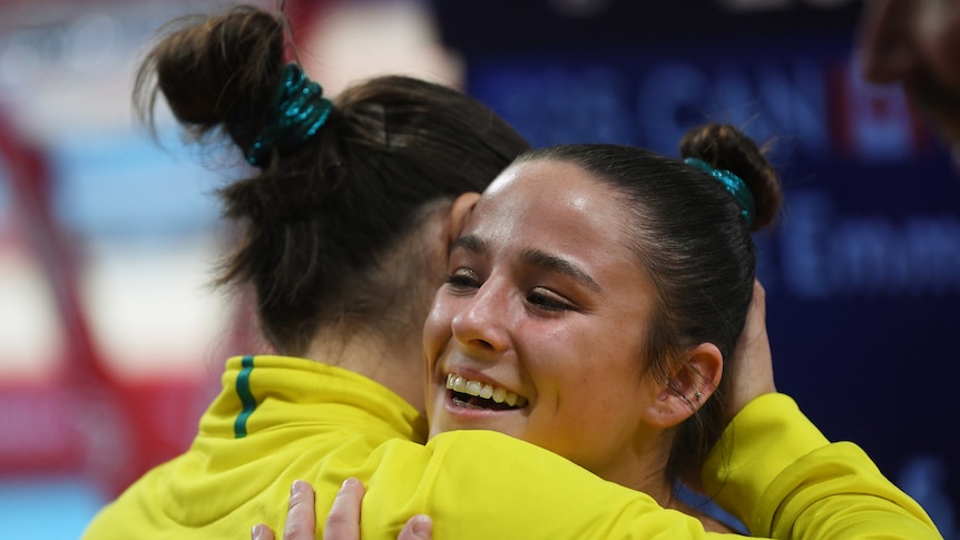 Kate McDonald hugs fellow Australian Georgia Godwin after the Women's Balance Beam final