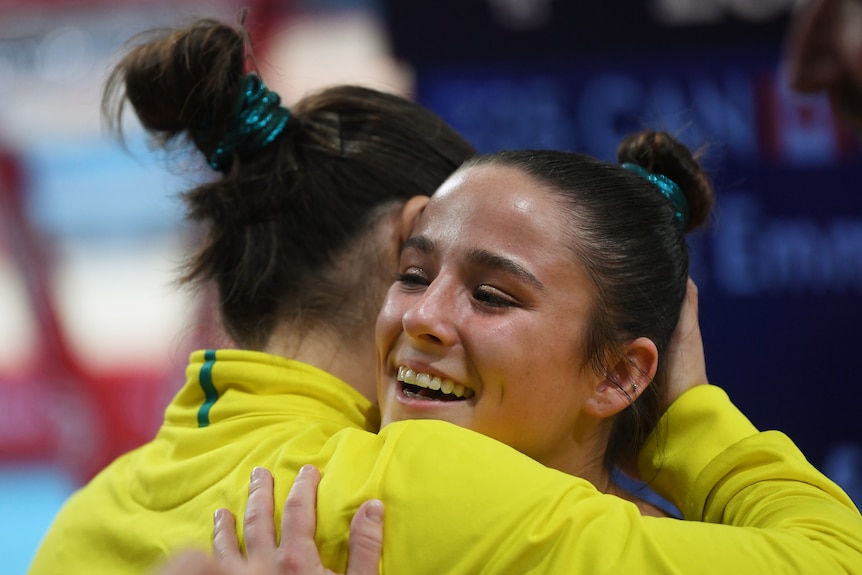 Kate McDonald hugs fellow Australian Georgia Godwin after the Women's Balance Beam final