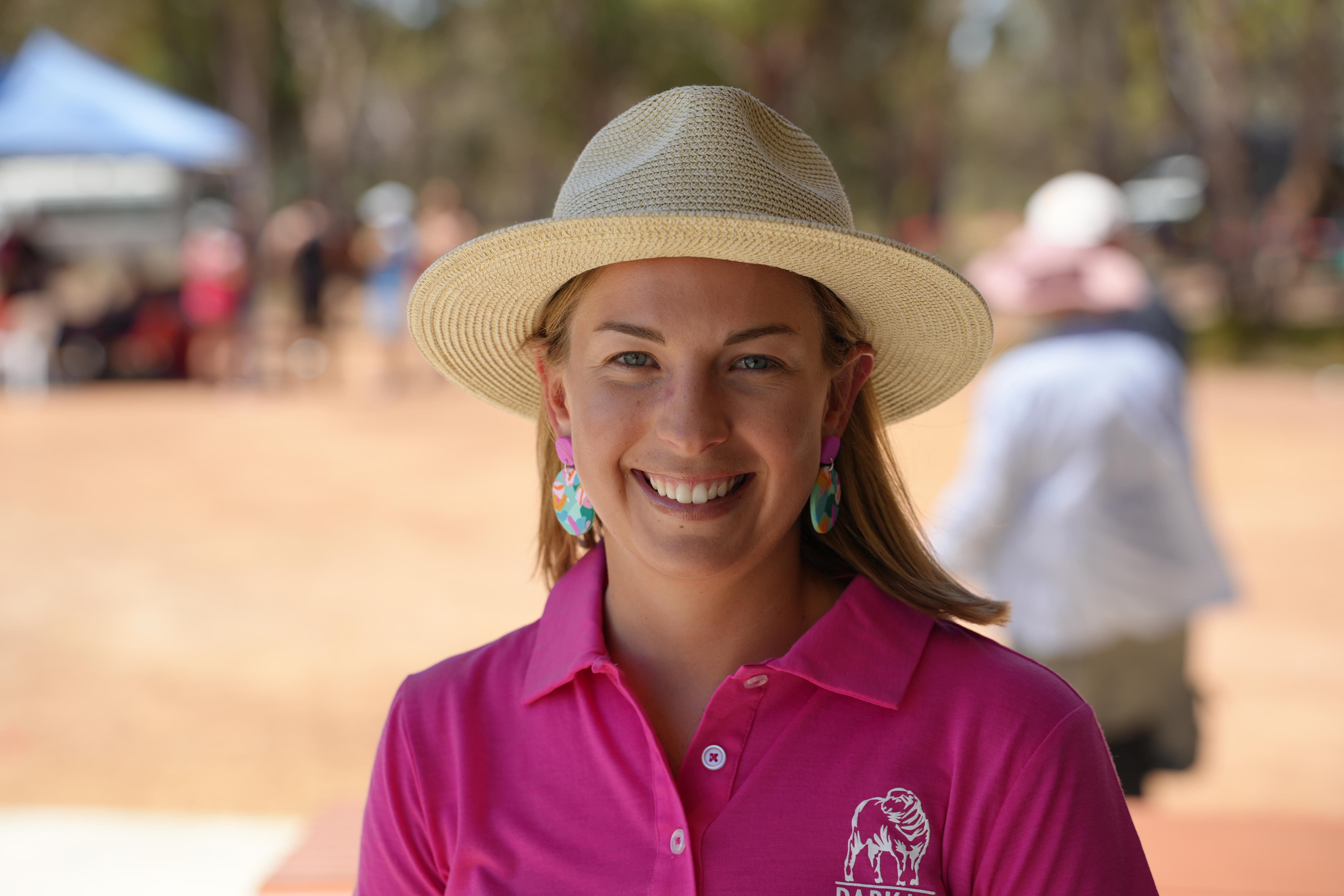 a girl in a pink shirt and white hat 