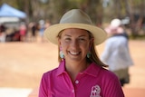 a girl in a pink shirt and white hat 