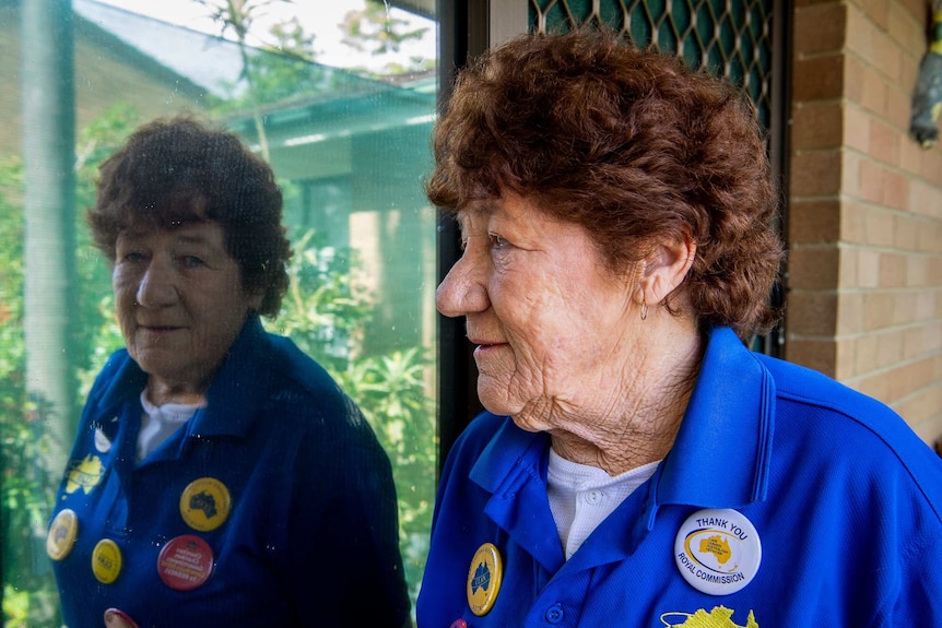 Lyn Belsham looks away at an angle as her reflection looks into the camera.