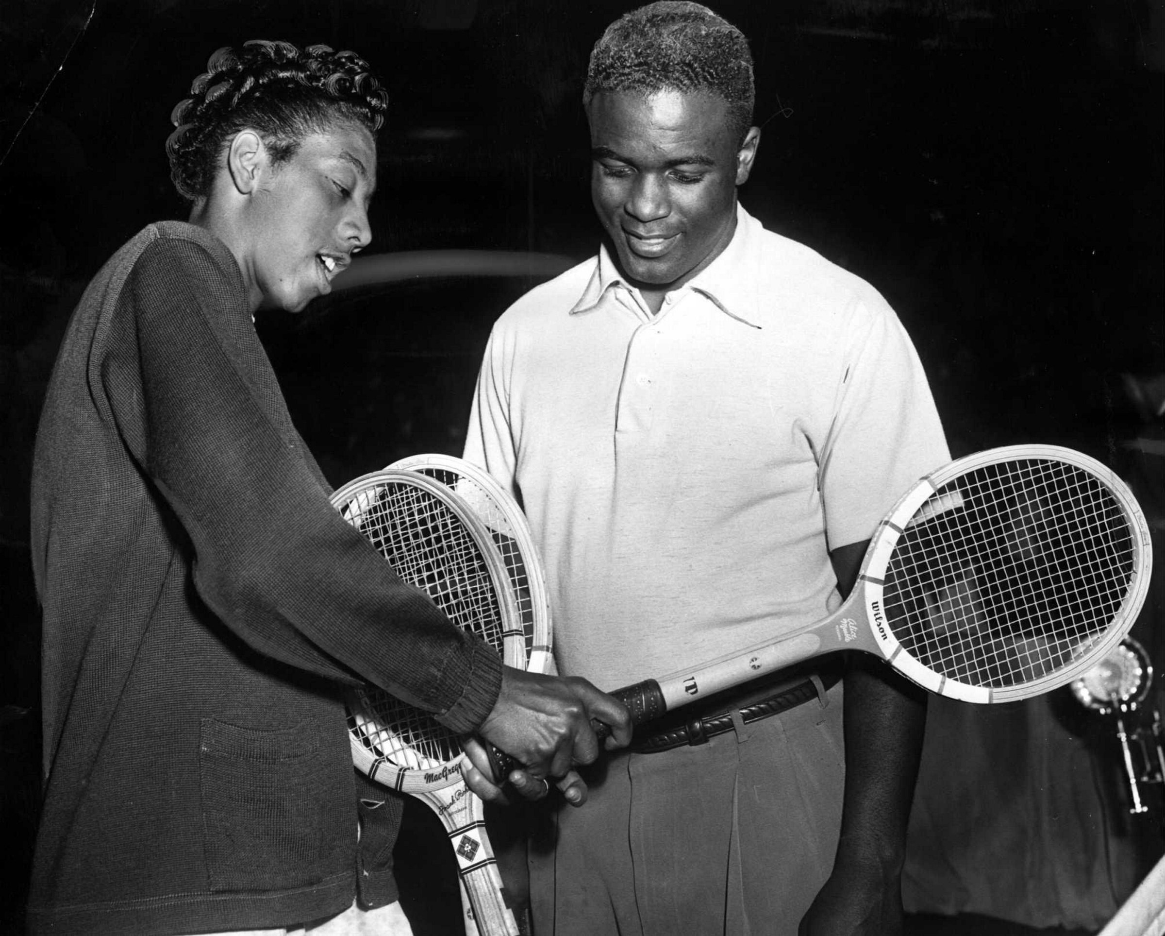 Althea Gibson mostra sua habilidade no tênis enquanto conversa com o ícone do beisebol Jackie Robinson.
