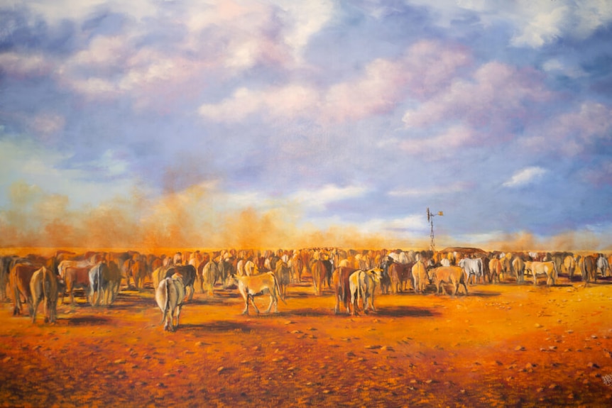 Cattle standing in red dust in cattle yards.