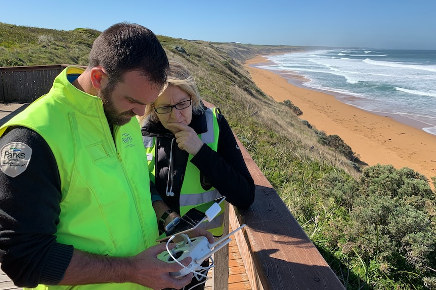 Man and woman checking drone