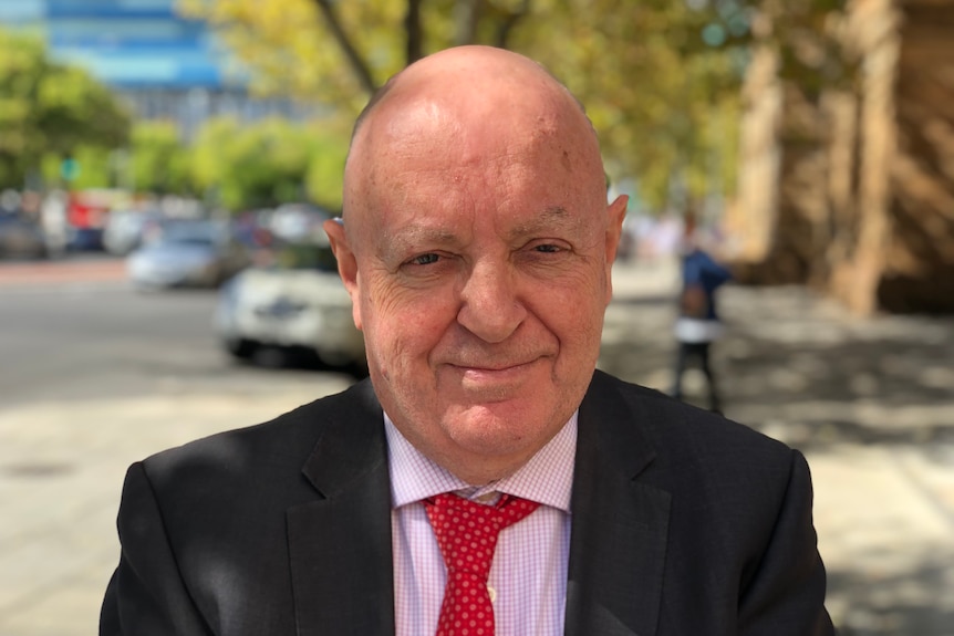 A close-up photo of a man in a suit and tie.