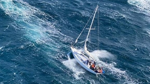 Aerial view of a yacht in choppy sea.