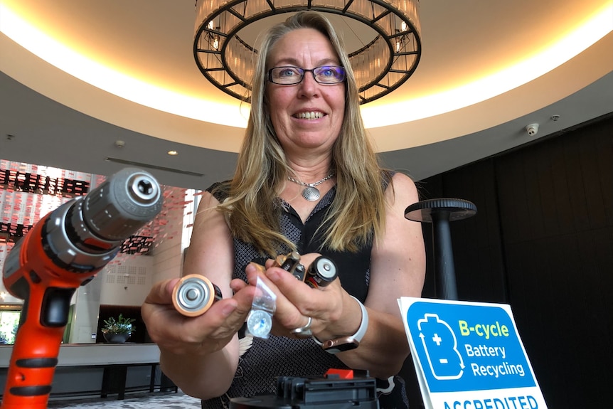 a woman holding batteries in her hands