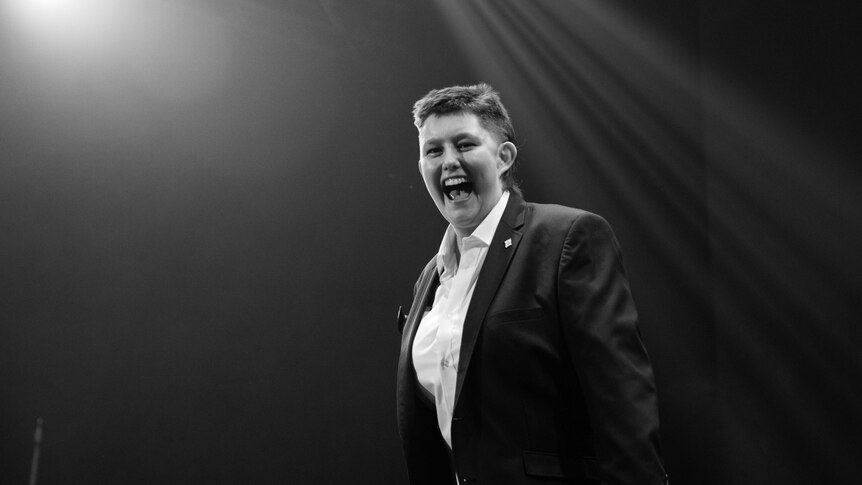 A black and white portrait of Alissia Marsh laughing on stage.