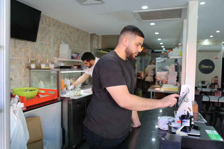 Cafe owner works the till