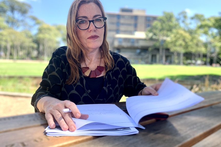 a woman with documents in a park