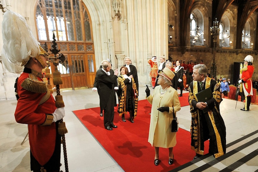The Queen points to the ceiling in the Palace of Westminster.