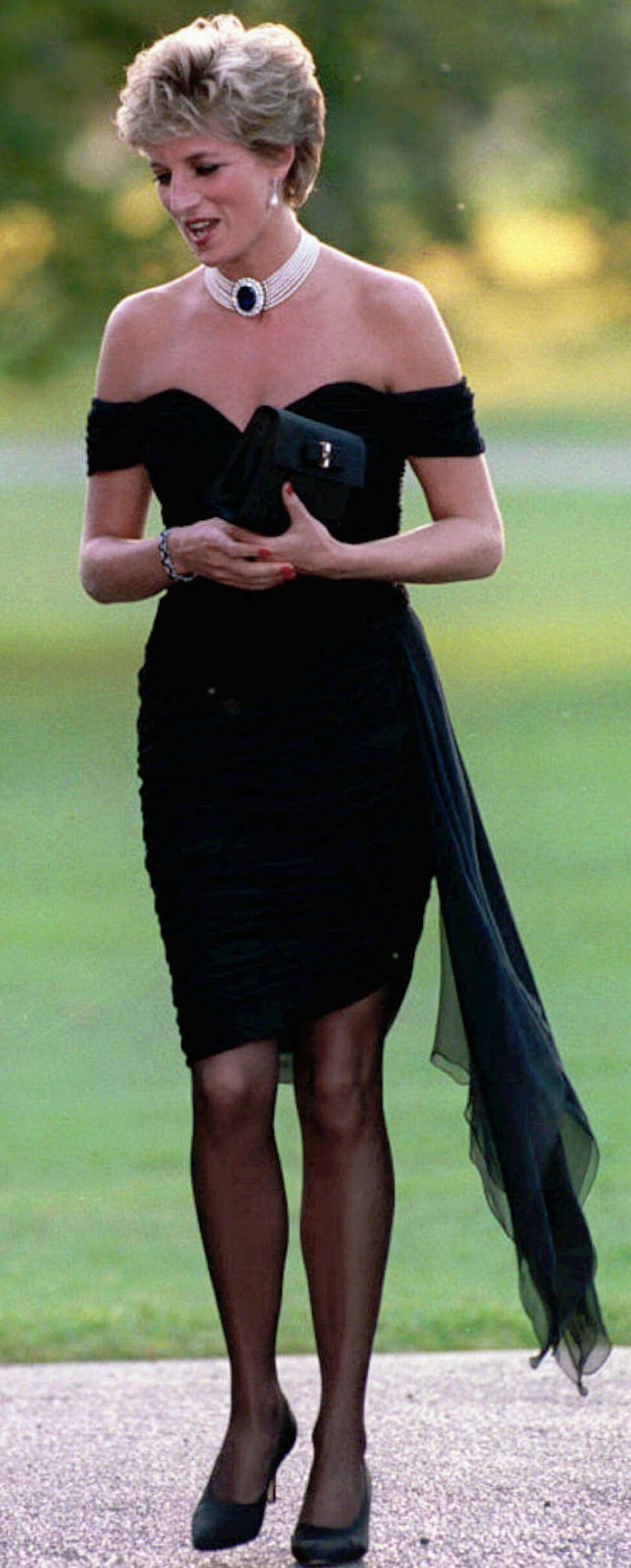 Princess Diana wearing a tight black off-the-shoulder mini dress with a pearl choker