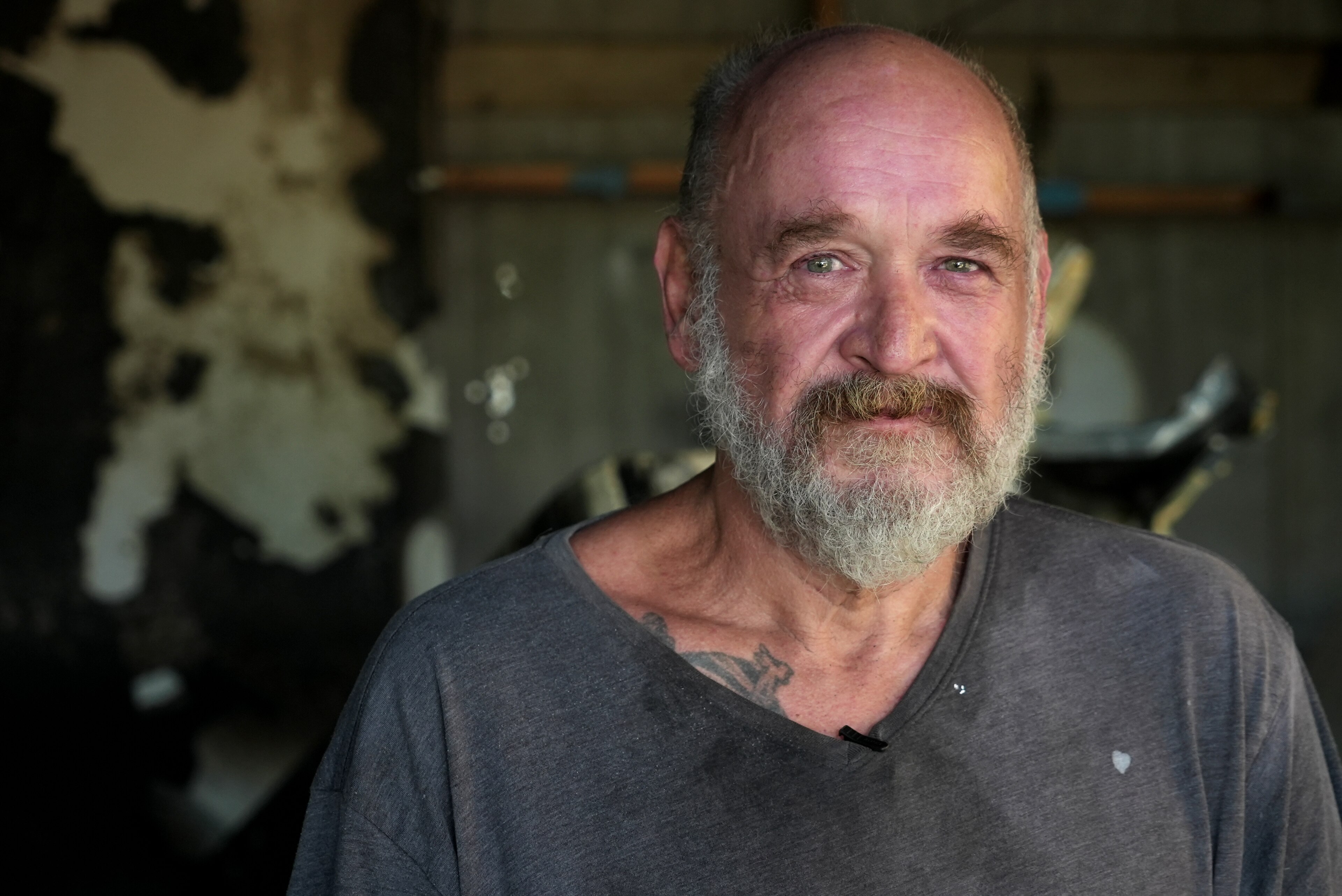 A man standing in the burnt remains of a house