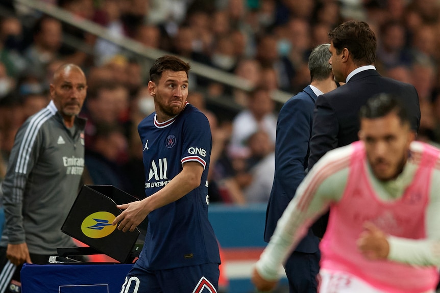 Soccer player walking away from his coach shrugging his shoulders after being substituted